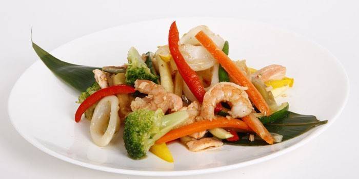 Salada de camarão frito, frutos do mar e legumes em uma folha de bananeira