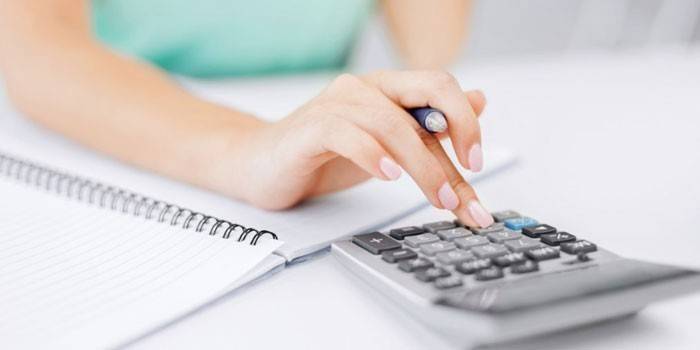 Chica hace cálculos en una calculadora