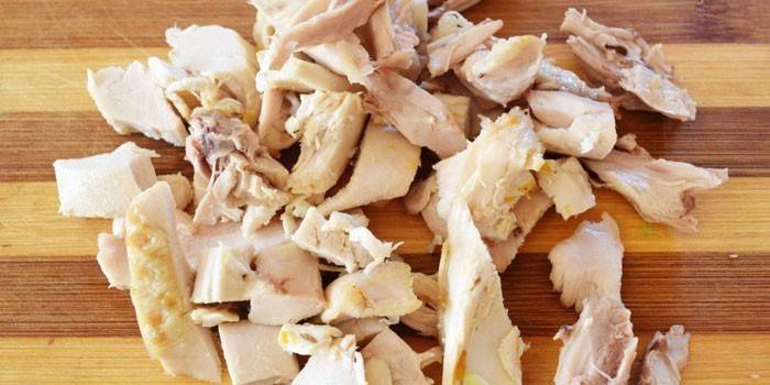 Rodajas de pollo hervido en una tabla de cortar