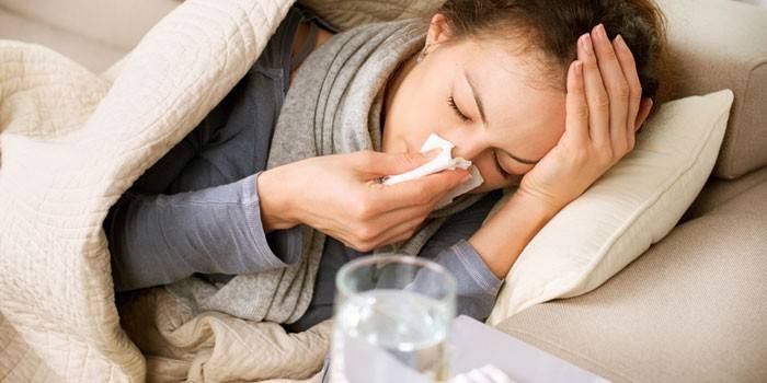 A menina encontra-se na cama e está doente