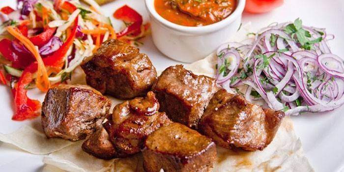 Carne de porco fatiada com saladas e molho