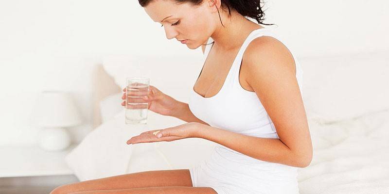 Mujer con una tableta y un vaso de agua.