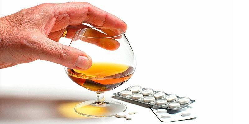 Comprimidos e álcool em um copo