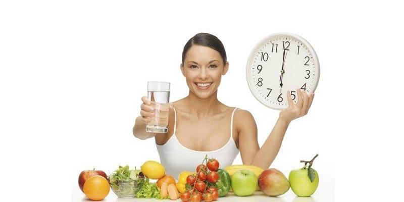 Menina com um copo de água e frutas
