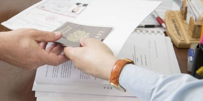 Ludzie przekazują paszport z ręki do ręki
