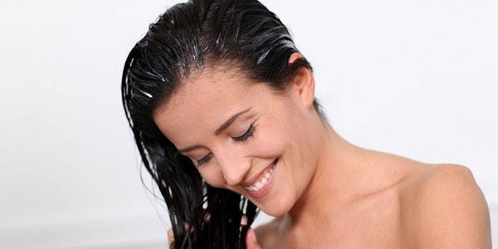 Mujer aplica bálsamo para el cabello