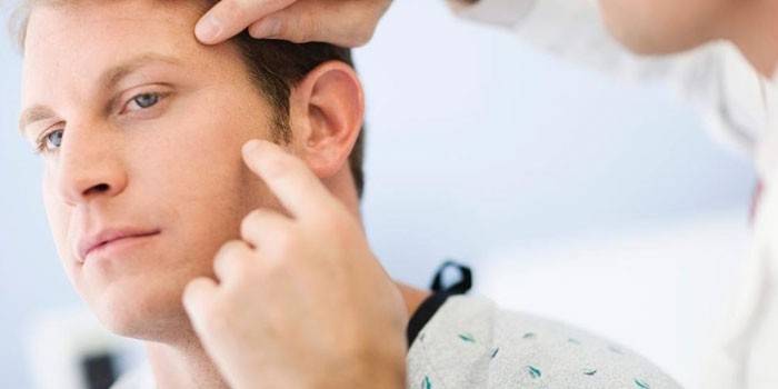 Homem na consulta com um dermatologista