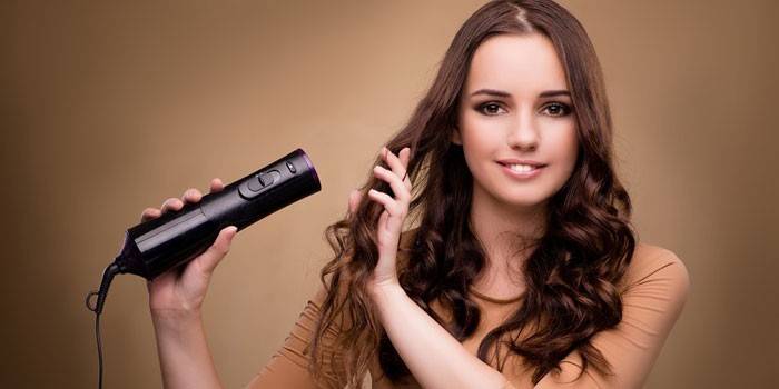 Mulher seca o cabelo com secador de cabelo