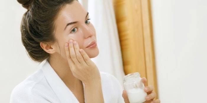Mujer pone aceite de coco en su cara