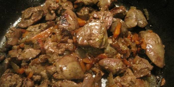 Hígado de pollo frito con zanahorias y cebollas en una sartén