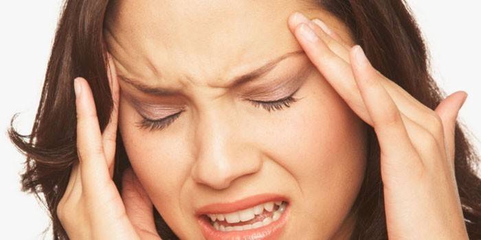 Una mujer tiene dolor de cabeza