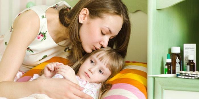 Mãe na cama de uma criança doente