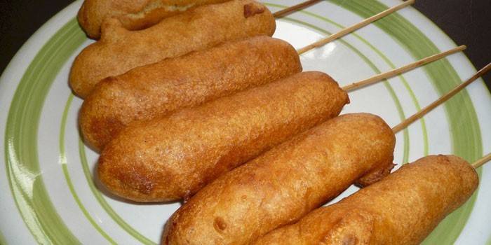 Salchichas fritas en un palo en la masa