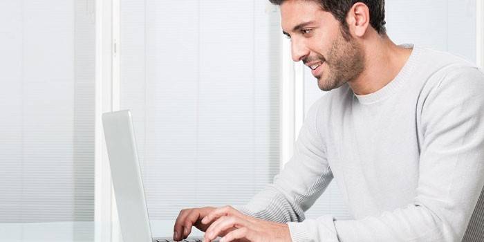 Um homem sentado em um laptop
