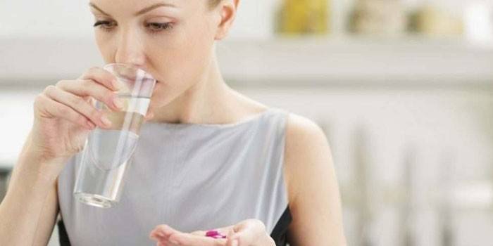 Mujer tomando pastillas