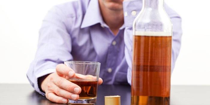 Hombre con un vaso de alcohol