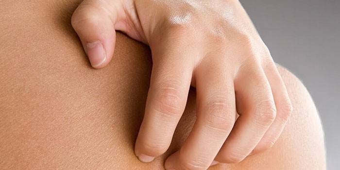 Mężczyzna drapie się po skórze po plecach