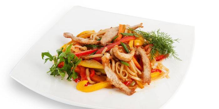 Udon com legumes e pedaços de carne de porco em um prato