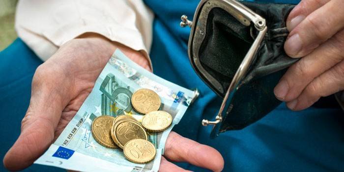 Bolsa e dinheiro nas mãos de uma pessoa