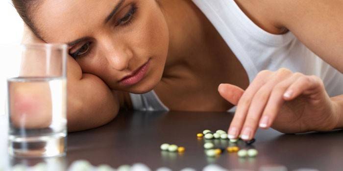Chica y pastillas sobre la mesa