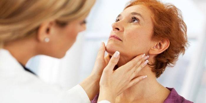 Um médico examina os gânglios linfáticos de uma mulher e a glândula tireóide.
