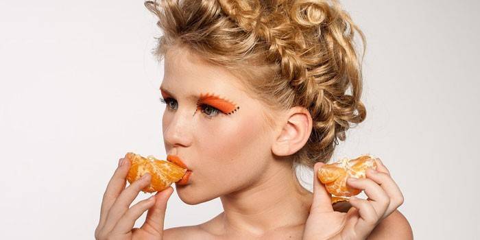 Niña comiendo mandarina