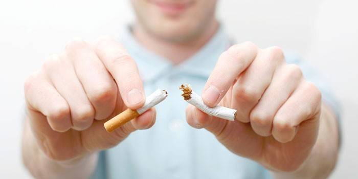 Hombre rompe un cigarrillo