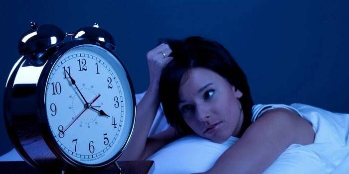 Menina na cama e um despertador
