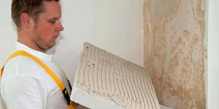 Mężczyzna kładzie panel na ścianie