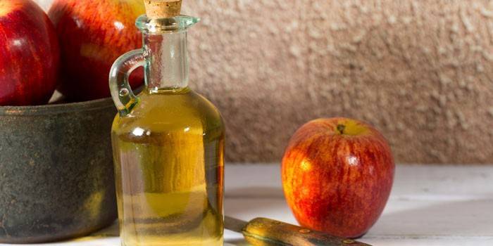 Gotowe wino jabłkowe w butelce i jabłkach