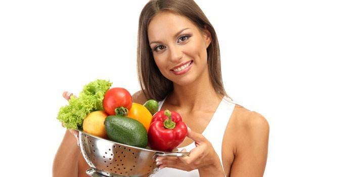 Niña sostiene vegetales en la mano