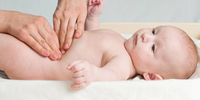 O médico palpa a barriga do bebê