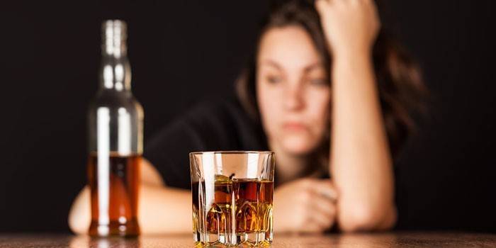 Whisky en un vaso, una botella y una niña