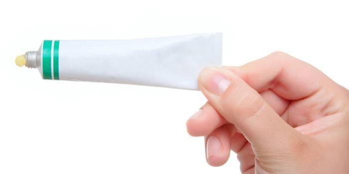 Tubo de pomada na mão