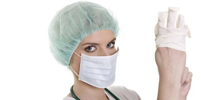 Menina médico coloca uma luva na mão dela