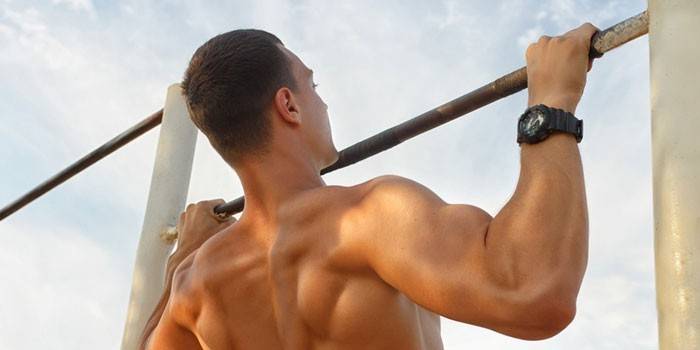 Um homem se levanta em uma barra horizontal