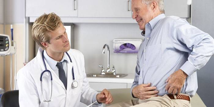 Un hombre muestra un lugar de dolor a un médico.