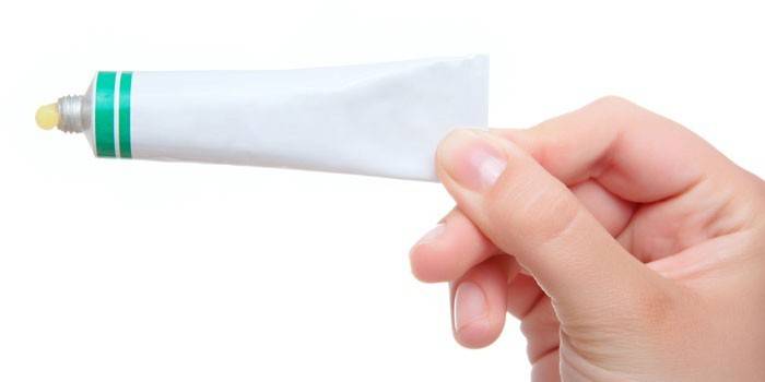 Tuba con ungüento en mano