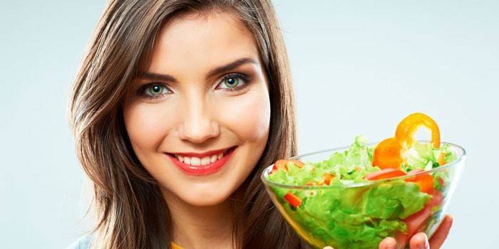 Niña sostiene un plato con ensalada