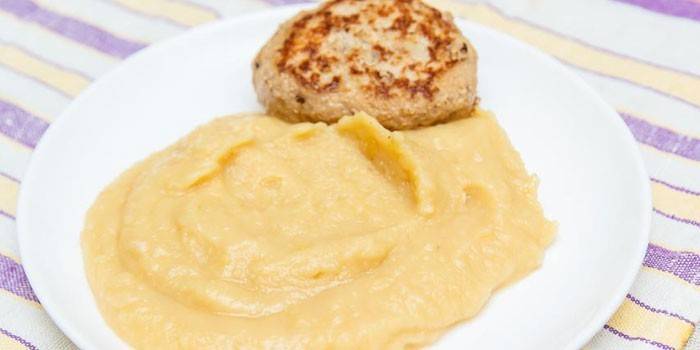 Gotowy puree z groszku z kotletem na talerzu