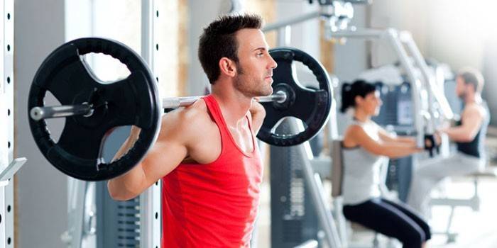 Un hombre con una barra en el gimnasio.