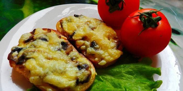 Gorące kanapki z pieczarkami i serem na talerzu z pomidorami