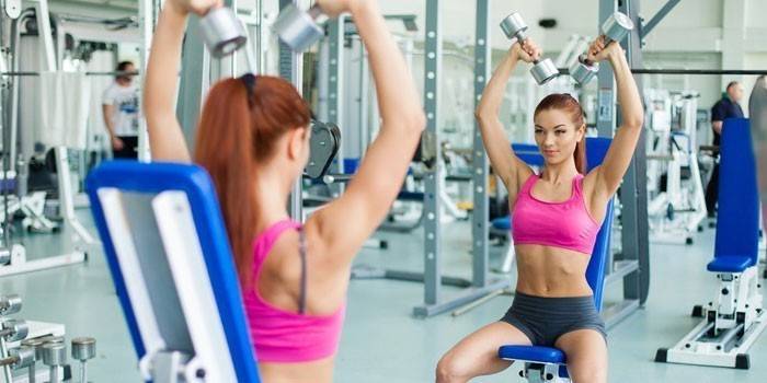 La niña está comprometida en el gimnasio.