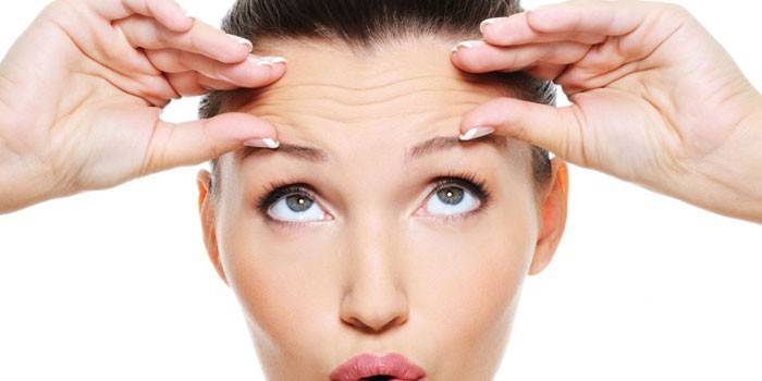 Garota faz uma massagem facial esculpida.