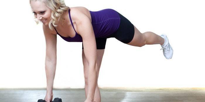 Menina realiza deadlift em uma perna com halteres.