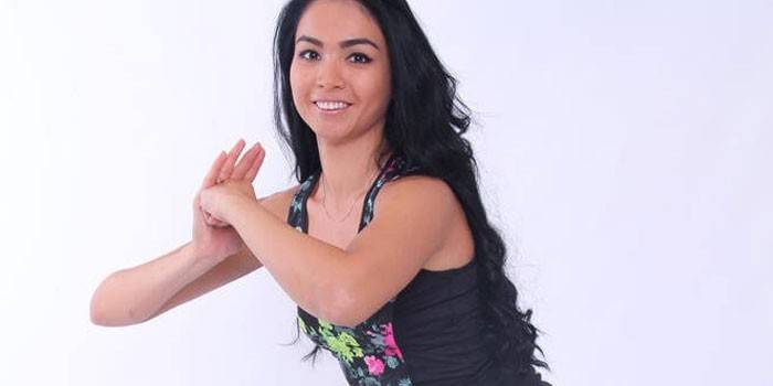 Garota fazendo um exercício estático sobre os músculos do peito
