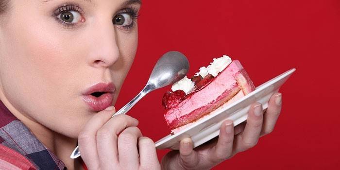 Menina com um pedaço de bolo em um prato nas mãos dela