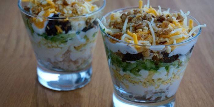 Dos vasos con una ensalada de pollo y pepinos frescos.
