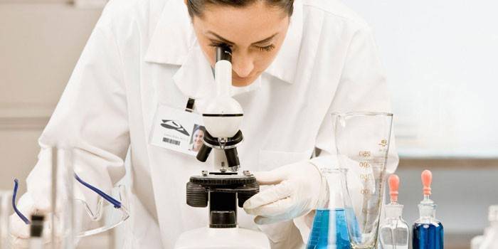 Technik laboratoryjny patrząc przez mikroskop