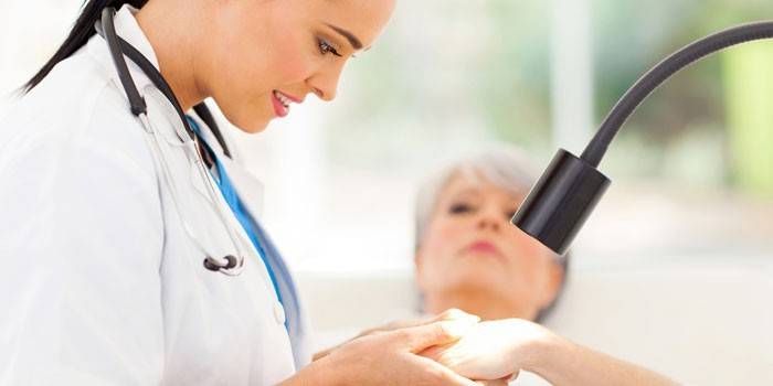 O médico examina a pele do paciente